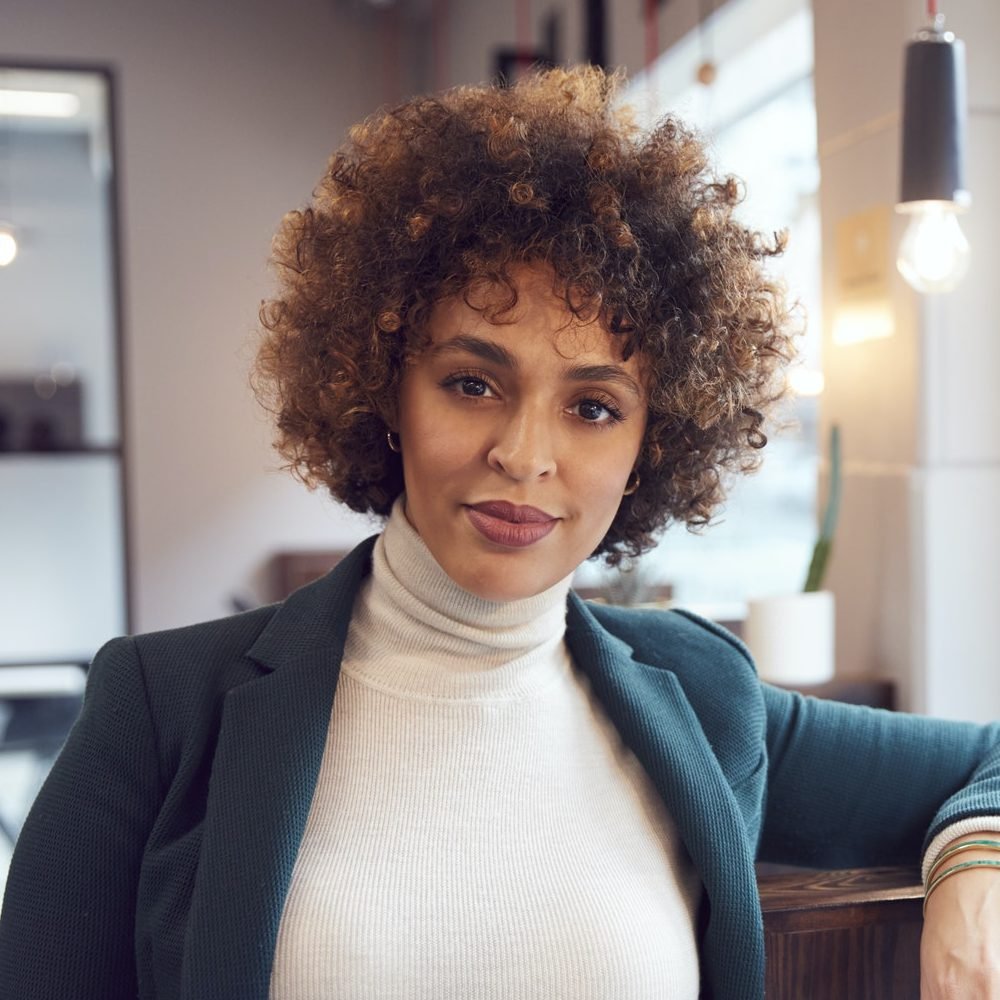 Head And Shoulders Portrait Of Businesswoman Working In Modern Office